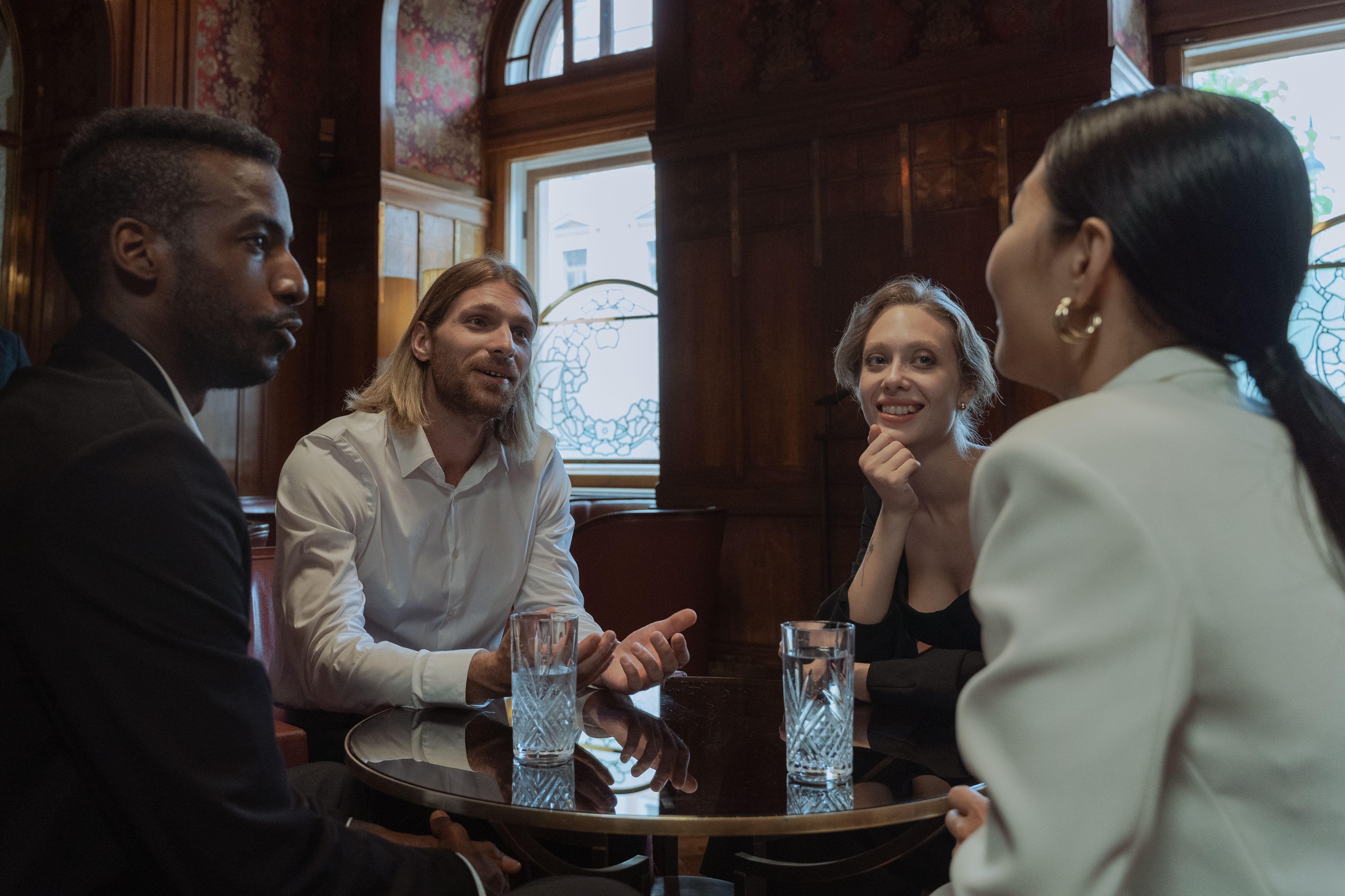 A diverse group in warm conversation at a cozy restaurant, illustrating social intelligence in practice