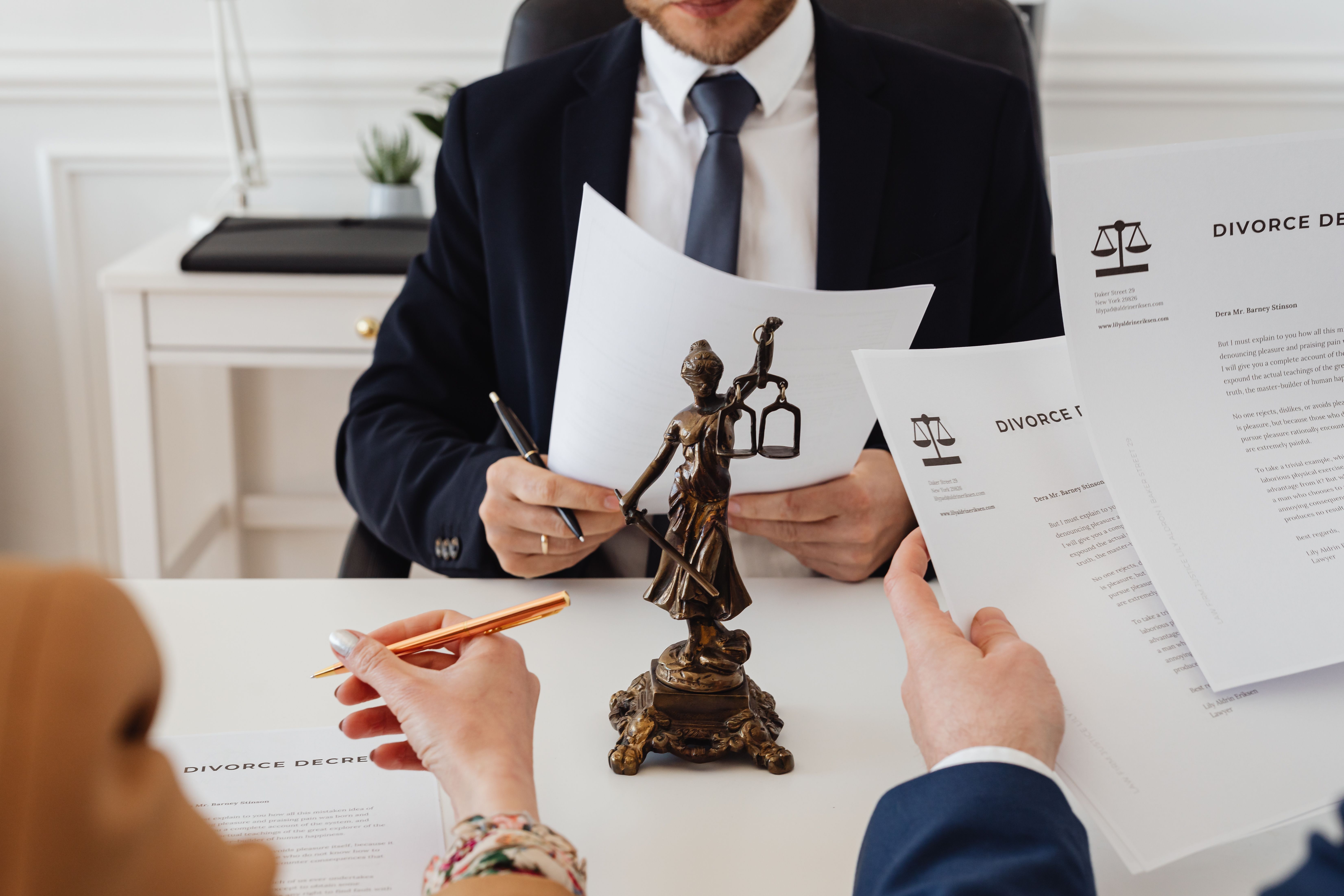 Legal professionals reviewing case documents in a law office with a Lady Justice statue