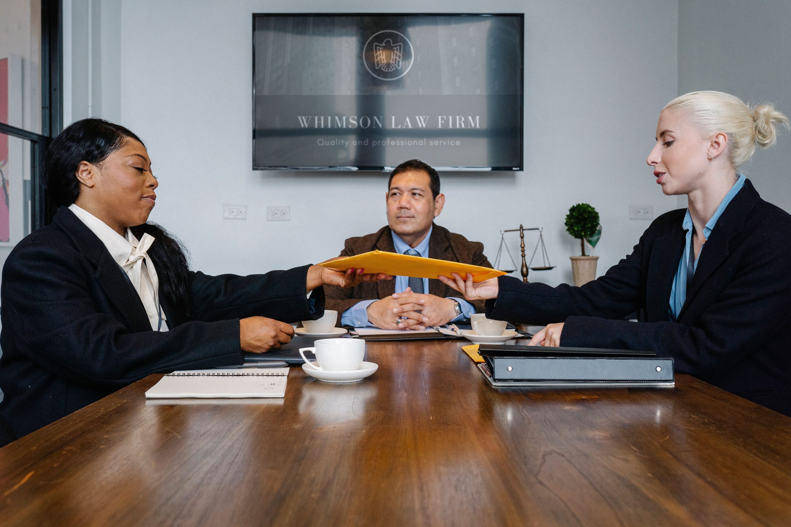 Group of diverse law firm colleagues meeting to discuss case costs and budgeting at a table