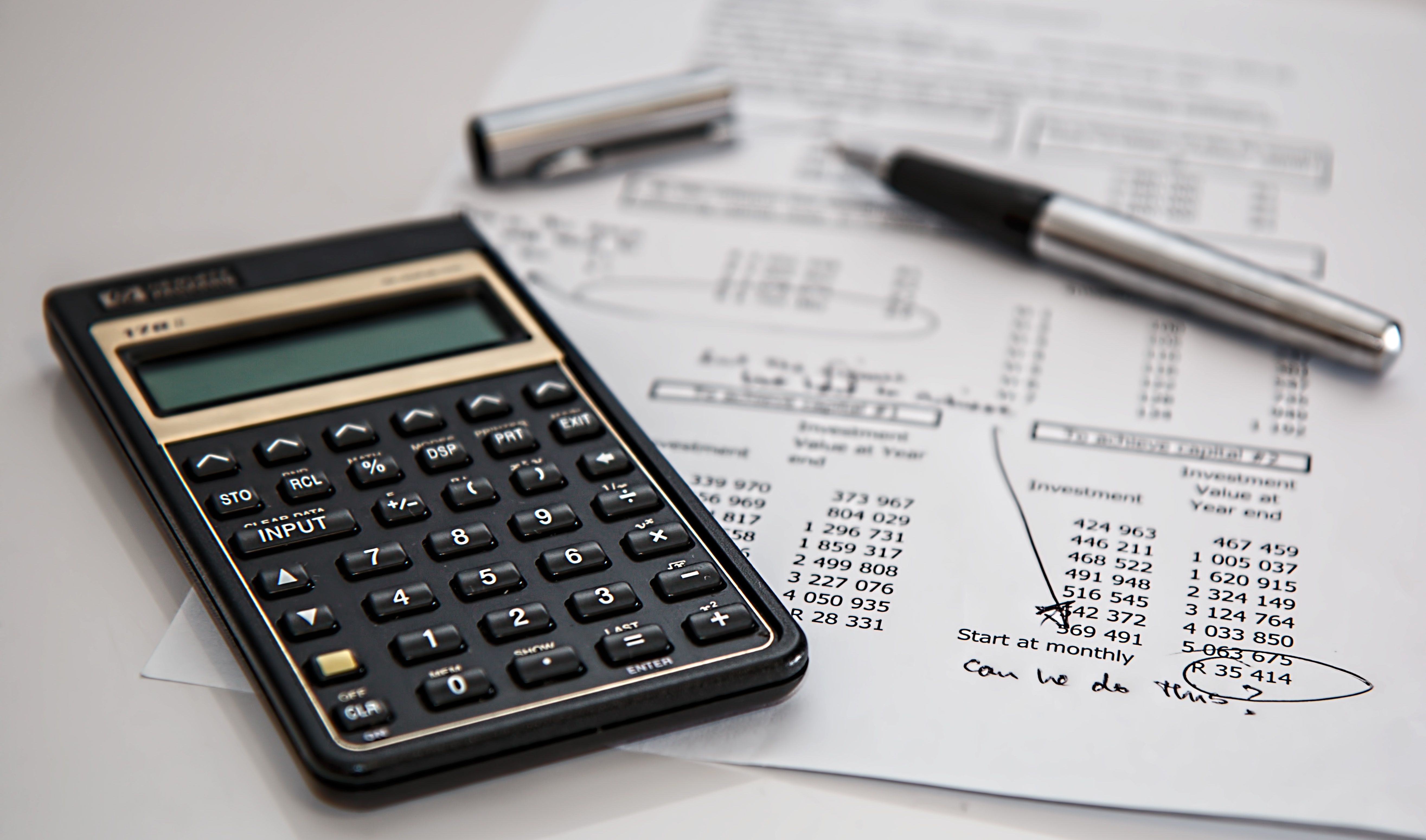 Close-up of financial documents with a calculator and pen used for tracking legal case expenses